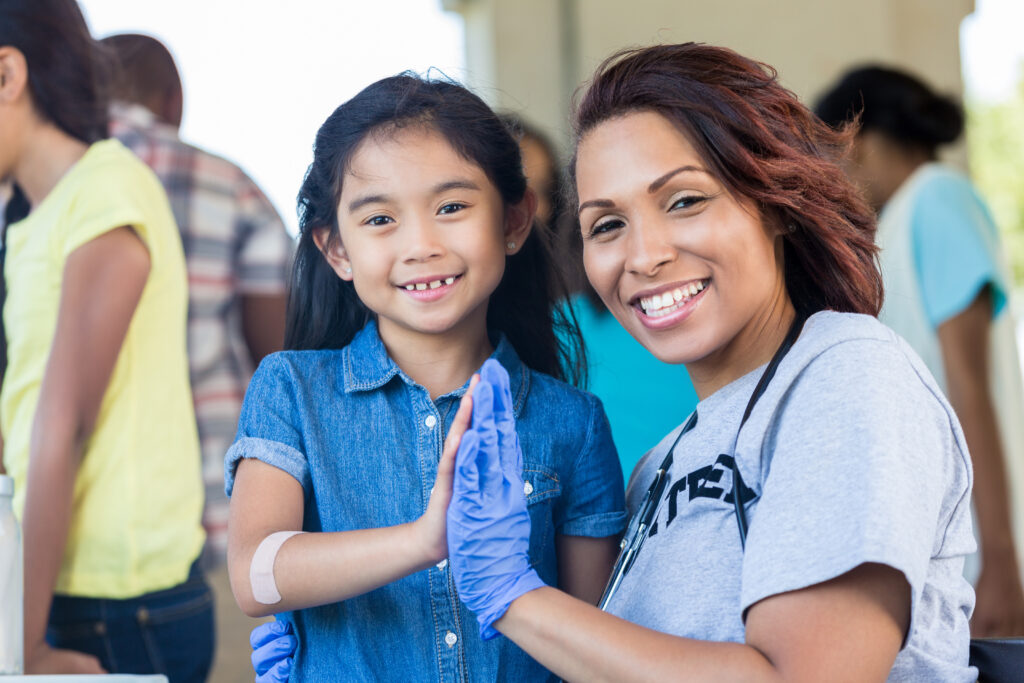 young girl and her doctor smiling and high-fiving